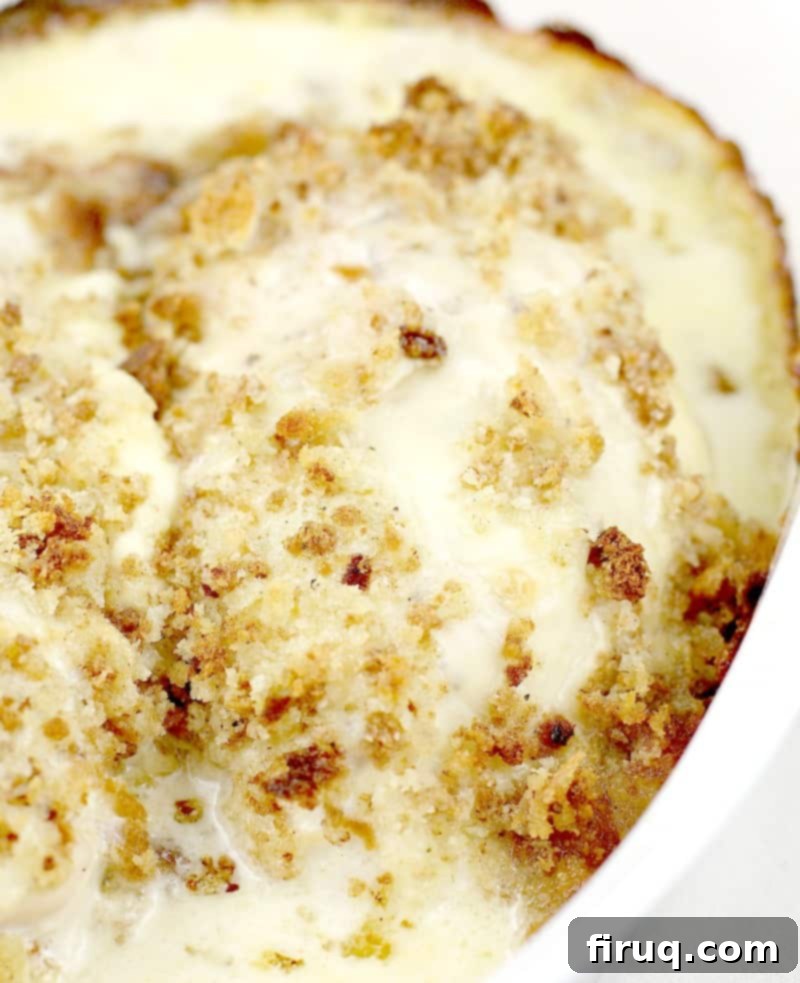 Baked Swiss Chicken Perfection 5 baked chicken in a white casserole dish topped with browned topping and surrounded with bubbly sauce