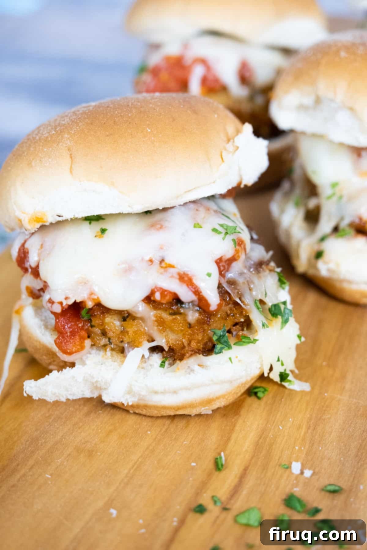 Mouthwatering Chicken Parm Minis 2 chicken parm sliders with tomato sauce and melted mozzarella