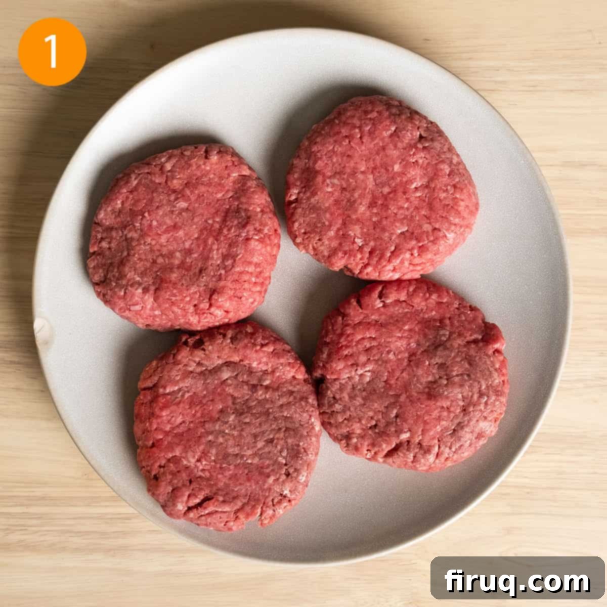 Sizzling Bacon & Bold Blue Cheese Burger 4 Four perfectly formed burger patties seasoned with salt and pepper, ready for grilling, arranged neatly on a plate.
