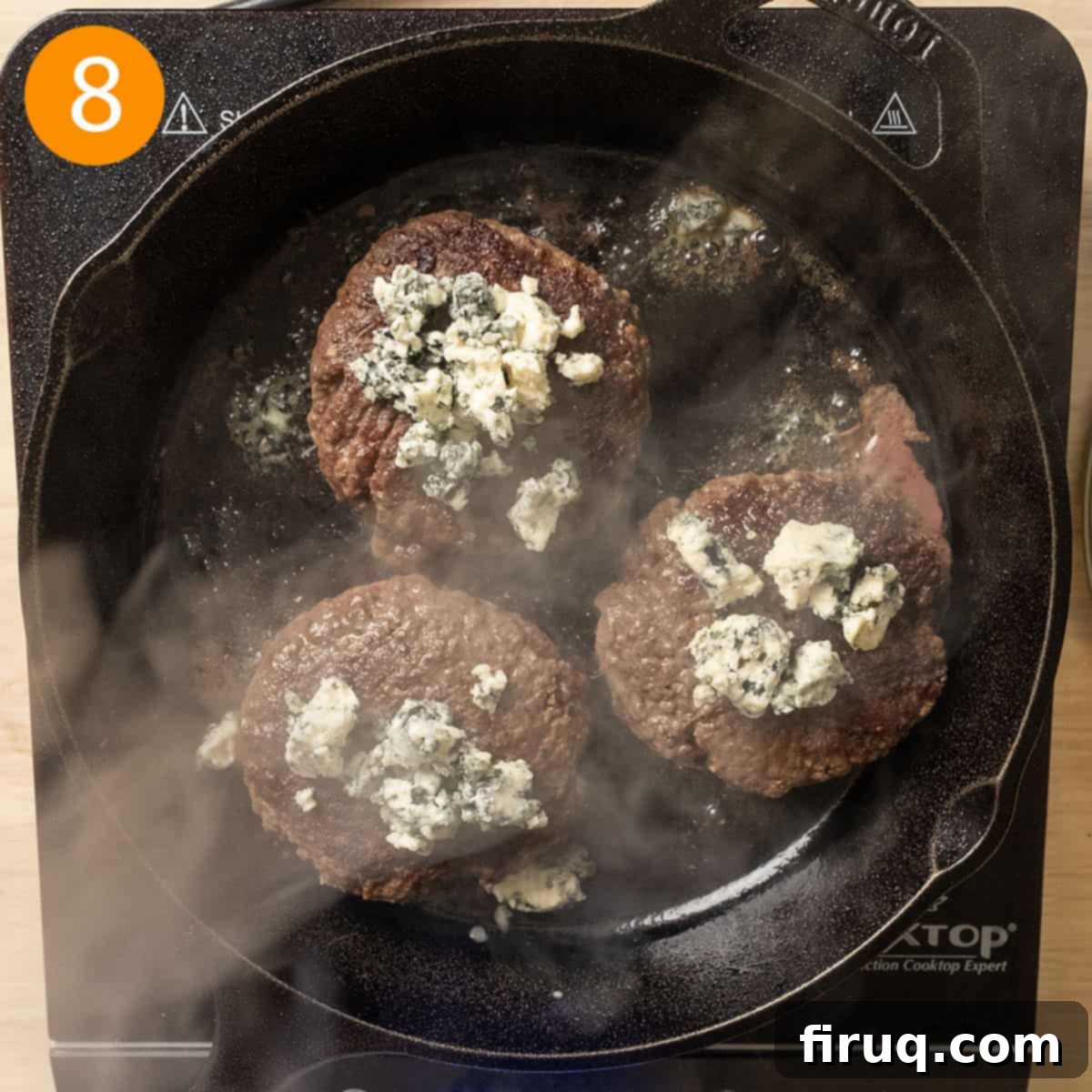 Sizzling Bacon & Bold Blue Cheese Burger 9 Grilling burgers topped with melting blue cheese crumbles, indicating they are almost ready.