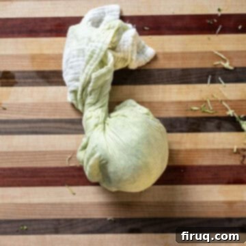 Guilt-Free Air Fryer Zucchini Fritters 6 Grated zucchini being squeezed in a cheesecloth to remove excess water.