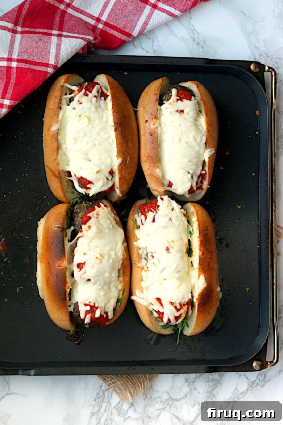 Delicious Meatball Subs Ready to Serve An overhead photo of four Meatball Subs on a baking tray.