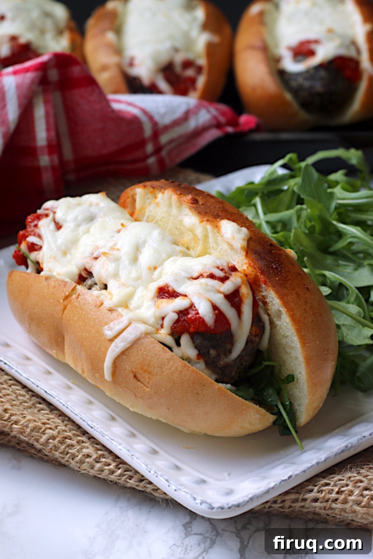 Perfectly Broiled Meatball Sub Meatball sub on a square white plate.