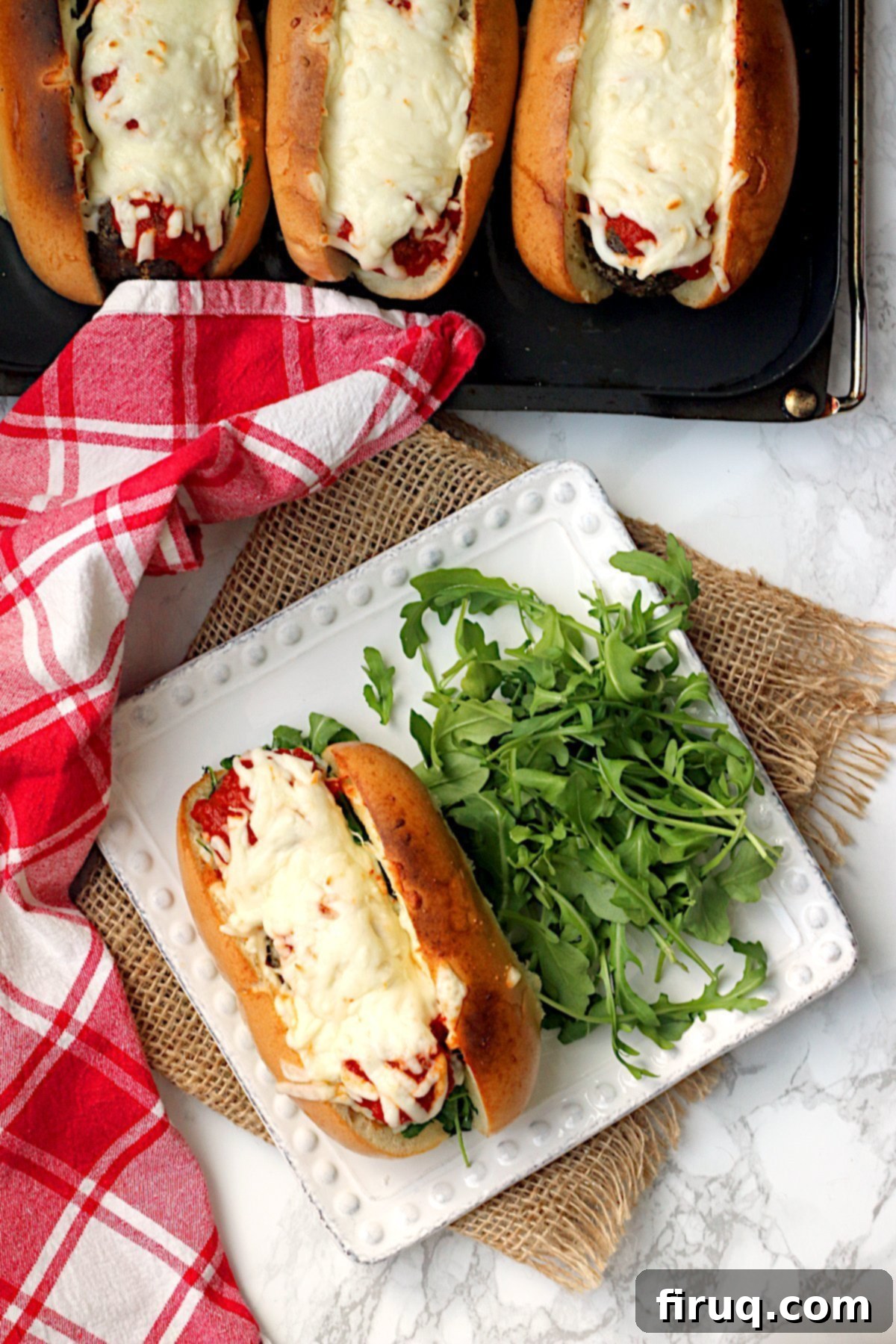 Ready-to-Eat Meatball Sub Overhead photo of a meatball sub on a square white plate.