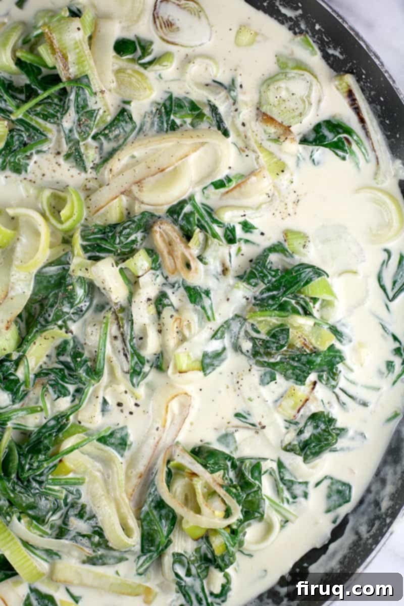 Gluten-Free Velvet Spinach & Leek Rotini 9 completed cream sauce in a skillet with cooked leeks and spinach