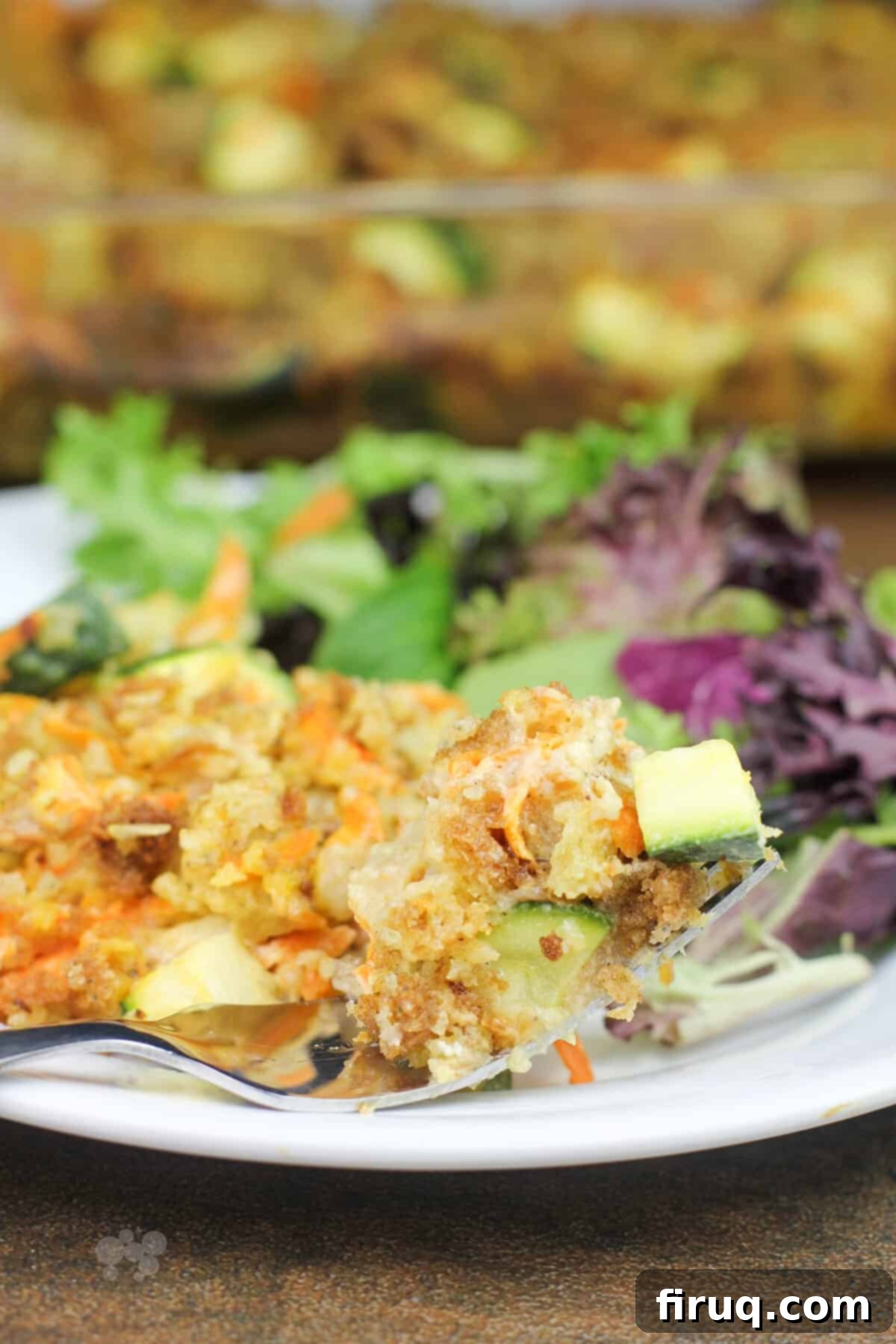 Comforting Chicken Zucchini Bake 11 A fork holding a bite of stuffing and zucchini from the casserole, showcasing the texture and combination of ingredients.