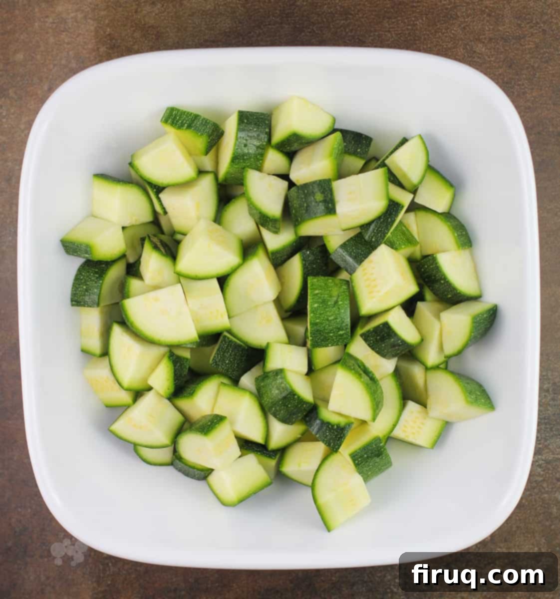 Comforting Chicken Zucchini Bake 5 Diced zucchini pieces neatly arranged in a white bowl, ready to be added to the casserole mixture.