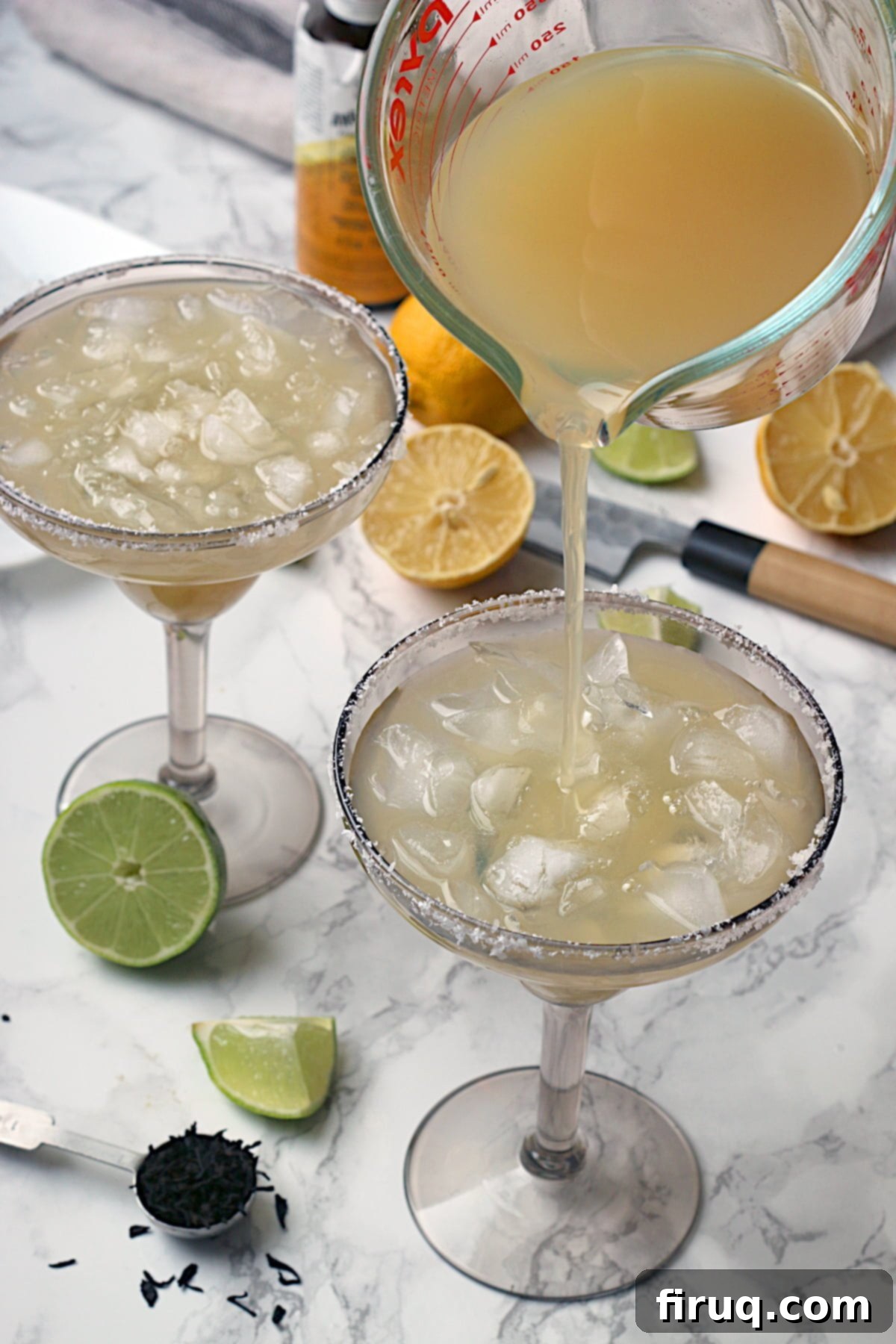Smoky Non-Alcoholic Lime Margarita Pouring a non-alcoholic lime margarita over ice in a smoky grey margarita glass.