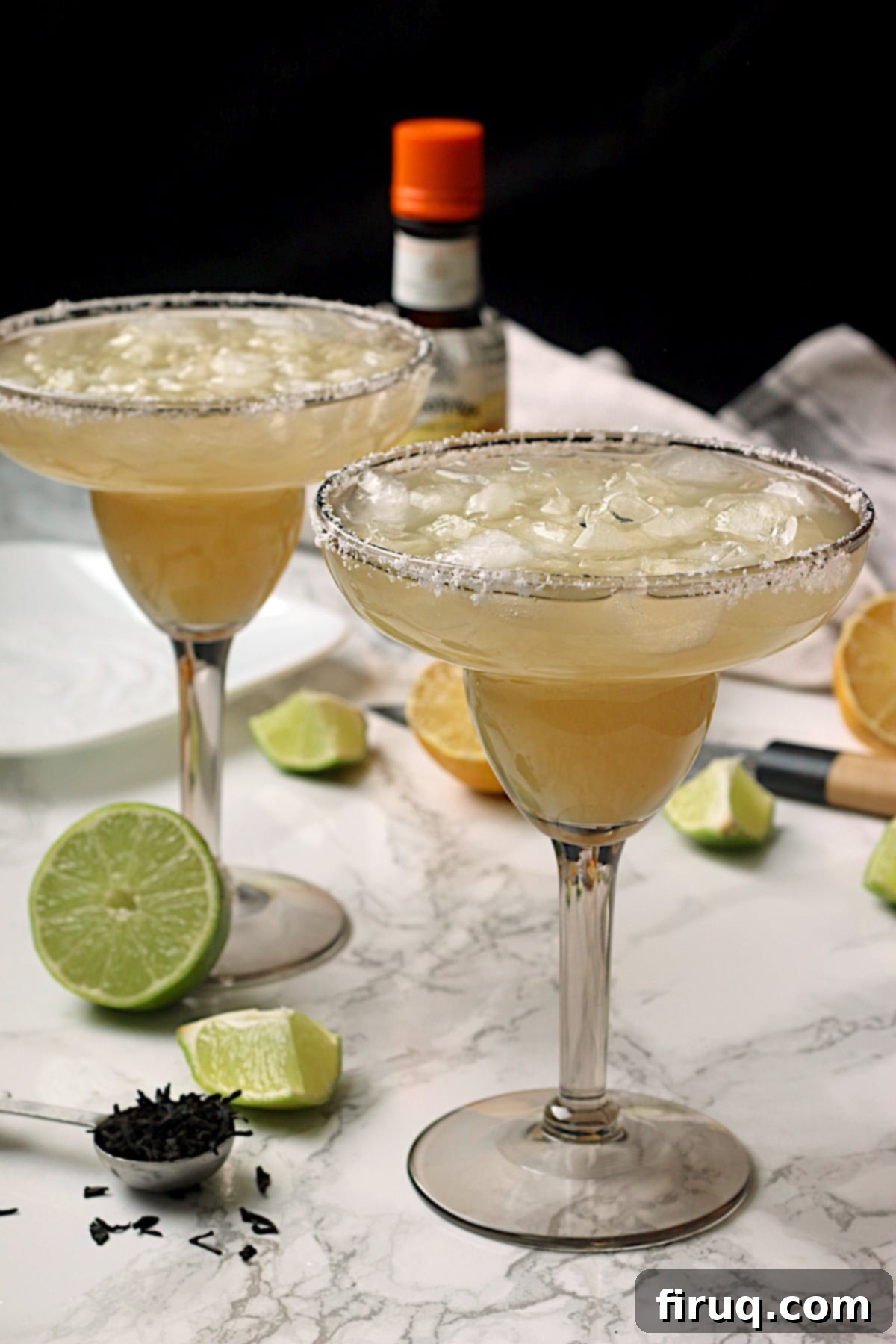 Two Smoky Mocktail Margaritas 2 non-alcoholic lime margaritas over ice in smoky grey margarita glasses.