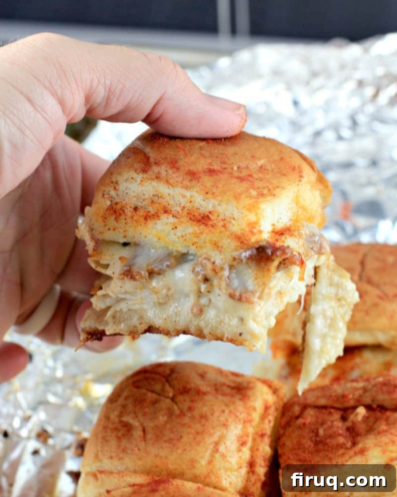 Aloha Maple Bacon Turkey Sliders 12 Another beautiful side view of a baked Hawaiian roll turkey slider being lifted, perfectly golden-brown with visible melted cheese and savory fillings.