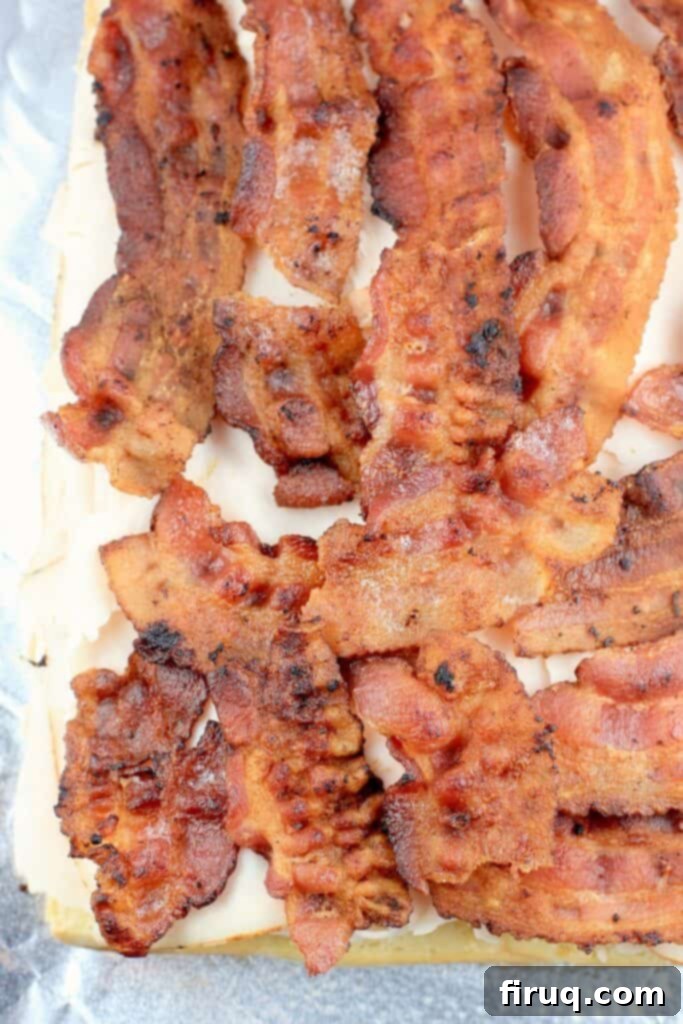 Aloha Maple Bacon Turkey Sliders 6 Top view of cooked maple bacon strips perfectly laid over the sliced deli turkey, ready for the final cheese layer.