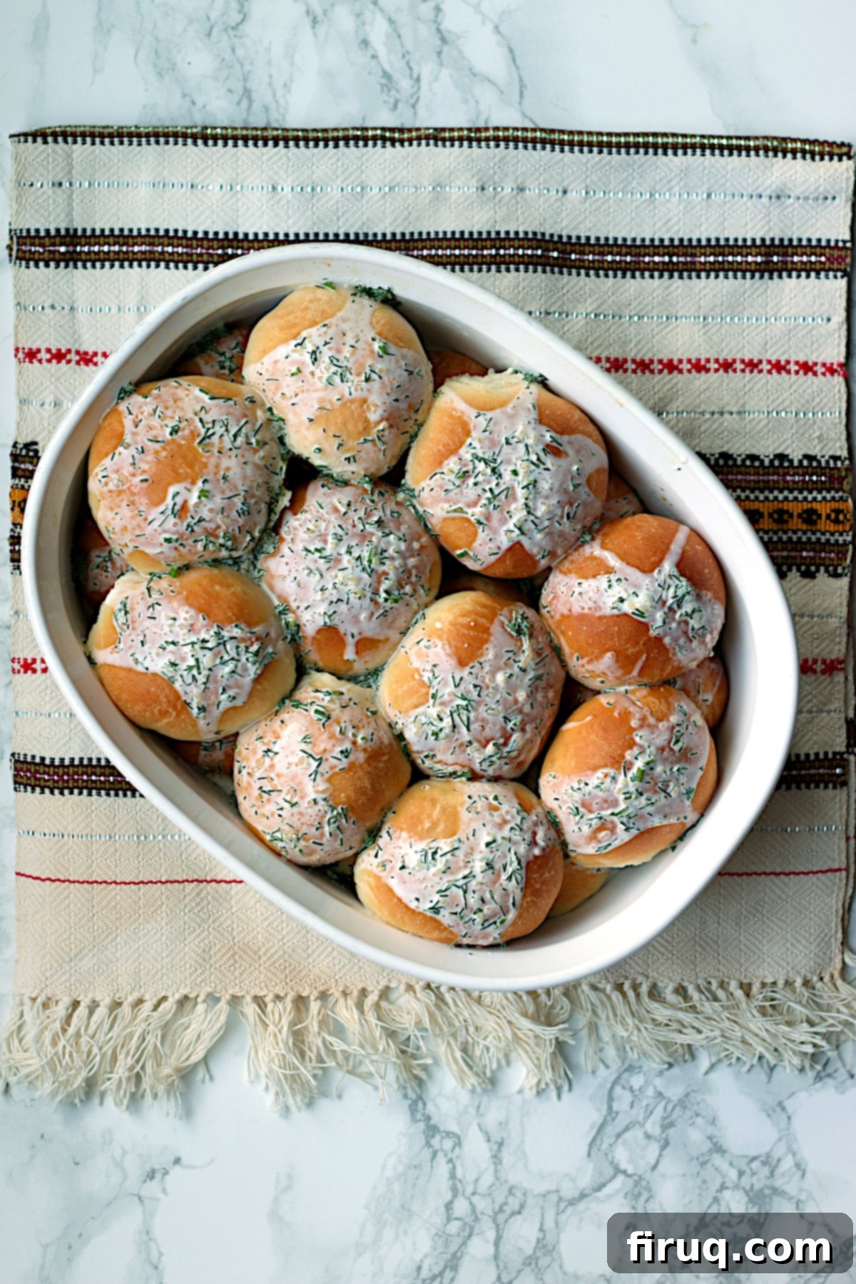 Ukrainian Perishky served with dill cream sauce Overhead photo of Ukrainian Perishky with dill cream sauce in a casserole dish, ready to serve.