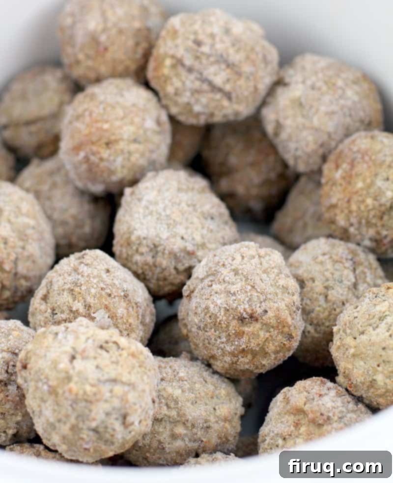 Slow Cooker Sweet Tangy Cranberry BBQ Meatballs 3 frosty frozen meatballs in a white ceramic crockpot