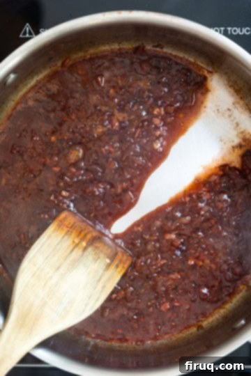 Fiery Shrimp Linguine Fra Diavolo 8 Spoon dragged through red wine reduction with sauce separating due to thickness.