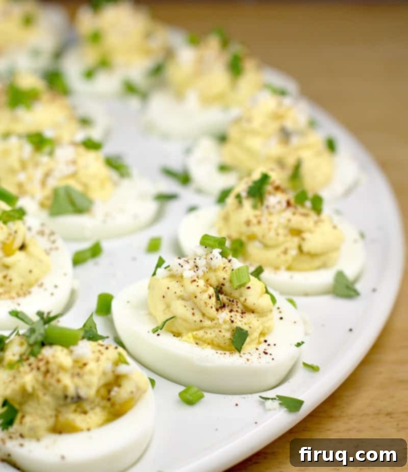 Elote Deviled Eggs 7 The finished Mexican street corn deviled eggs, beautifully arranged on a white serving plate, garnished and ready to be served