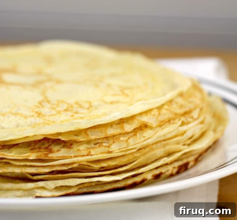 Easy Homemade Savory Crepes 8 thin crepes in a pile on a white dish, white background