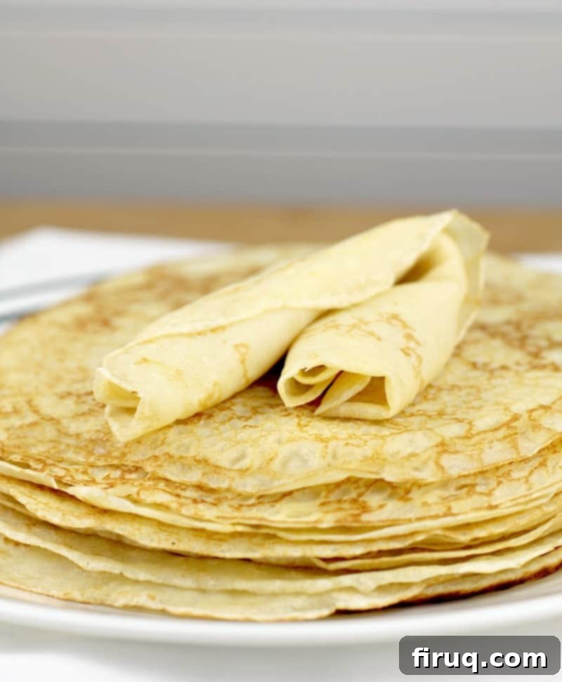 Easy Homemade Savory Crepes 9 stack of crepes with a rolled crepe on top