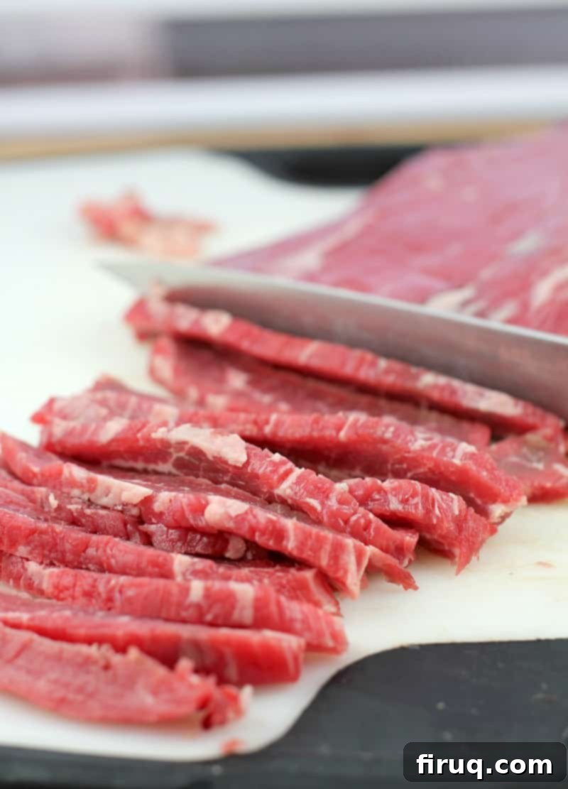 Homemade Beef Jerky Made Easy 6 knife slicing flank steak on white board