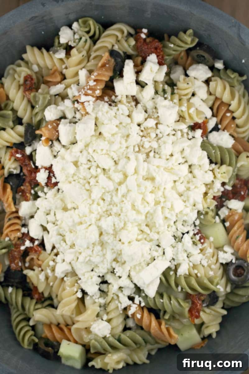 Vibrant Spinach Rotini Pasta Salad 5 feta cheese on top of pasta salad in a bowl