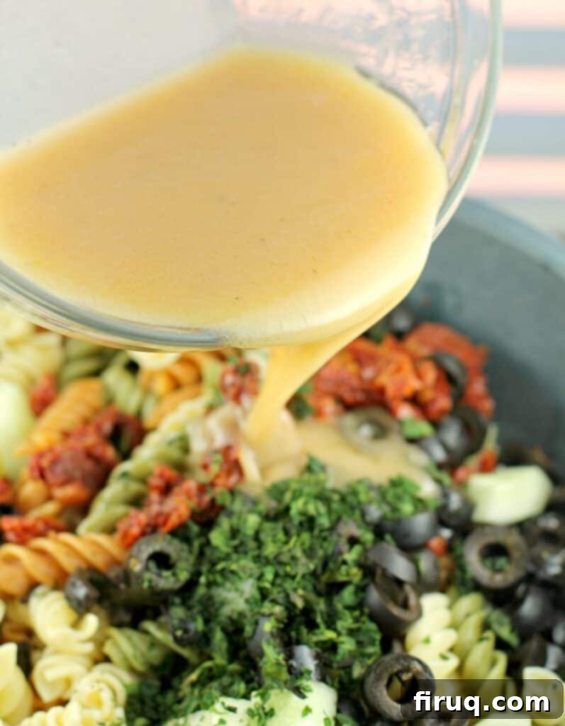 Vibrant Spinach Rotini Pasta Salad 6 vinaigrette pouring into salad