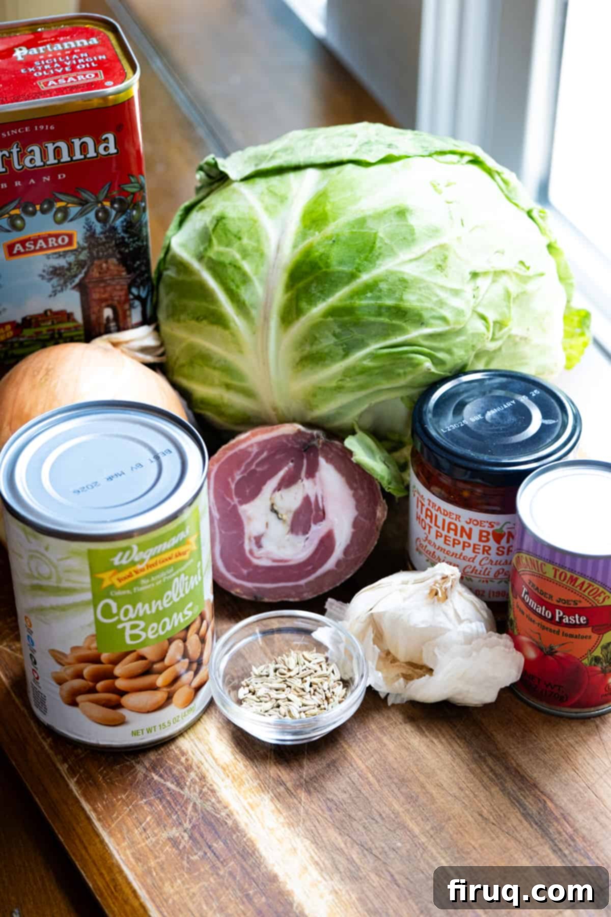 Hearty Italian Cabbage 3 Ingredients for Italian cabbage including pancetta, Calabrian peppers, fennel, tomato paste, cannellini beans, onion, and olive oil laid out