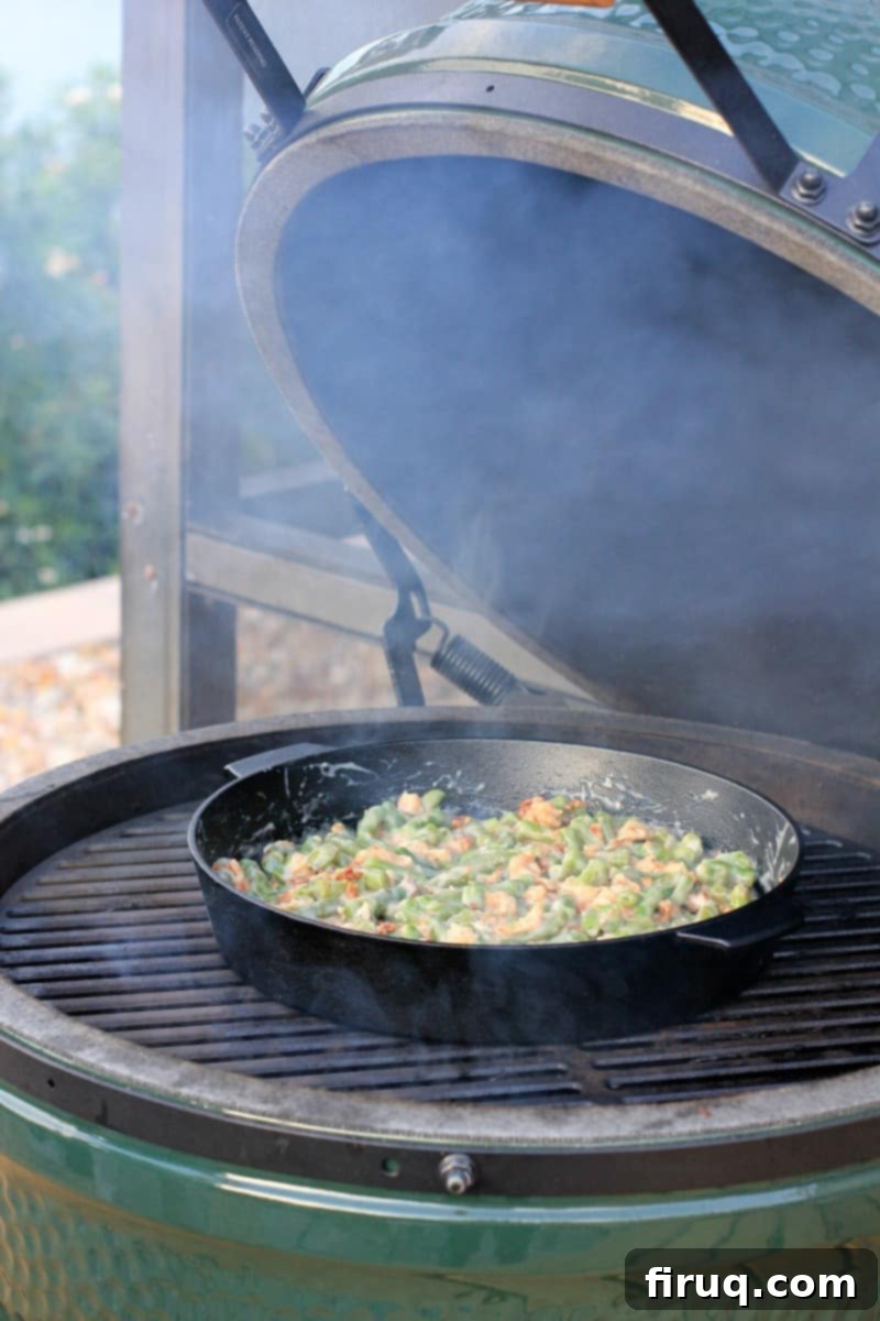 Grilled Green Bean Casserole with Crispy Bacon 7 A cast iron skillet filled with green bean casserole placed on the grill grates inside a Big Green Egg.