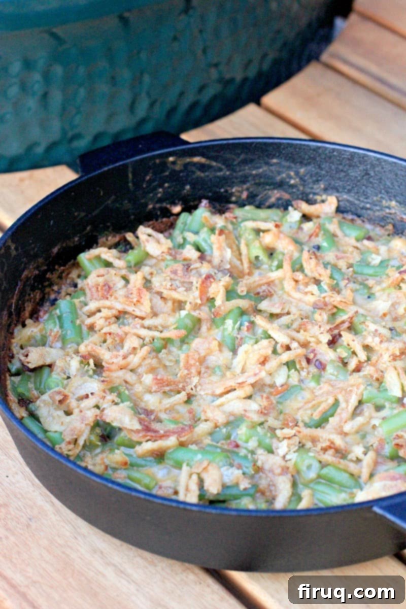Grilled Green Bean Casserole with Crispy Bacon 8 A piping hot, freshly grilled green bean casserole in a cast iron skillet, served outdoors next to a Big Green Egg.