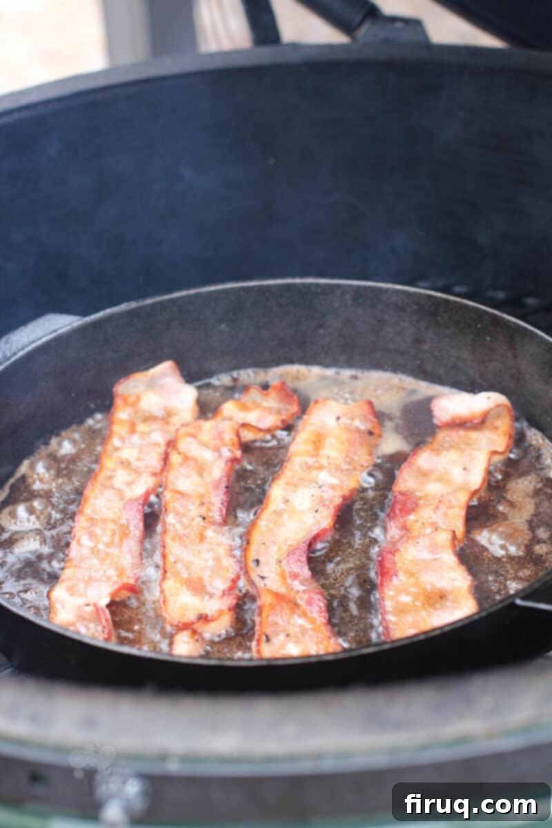 Grilled Beer-Infused Bacon Cheddar Joes 3 Crispy bacon sizzling in a cast iron skillet on a hot grill grate