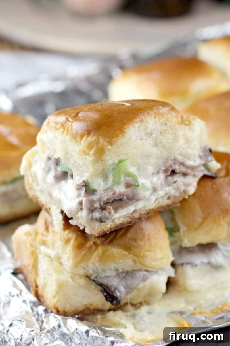 Grilled Beer-Infused Bacon Cheddar Joes 7 Two grilled Philly cheesesteak sliders stacked, showing roast beef, bell pepper, and cheese filling