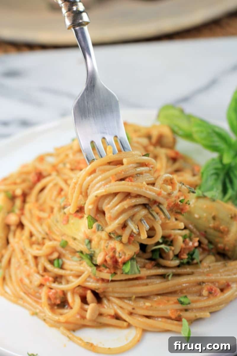 Rich Sun Dried Tomato Pesto Pasta 12 fork twirling up a bite of spaghetti with sauce