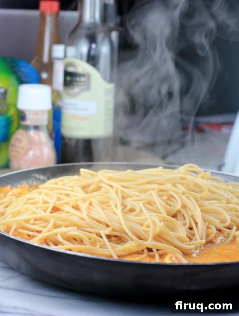 Rich Sun Dried Tomato Pesto Pasta 10 spaghetti steaming in a skillet