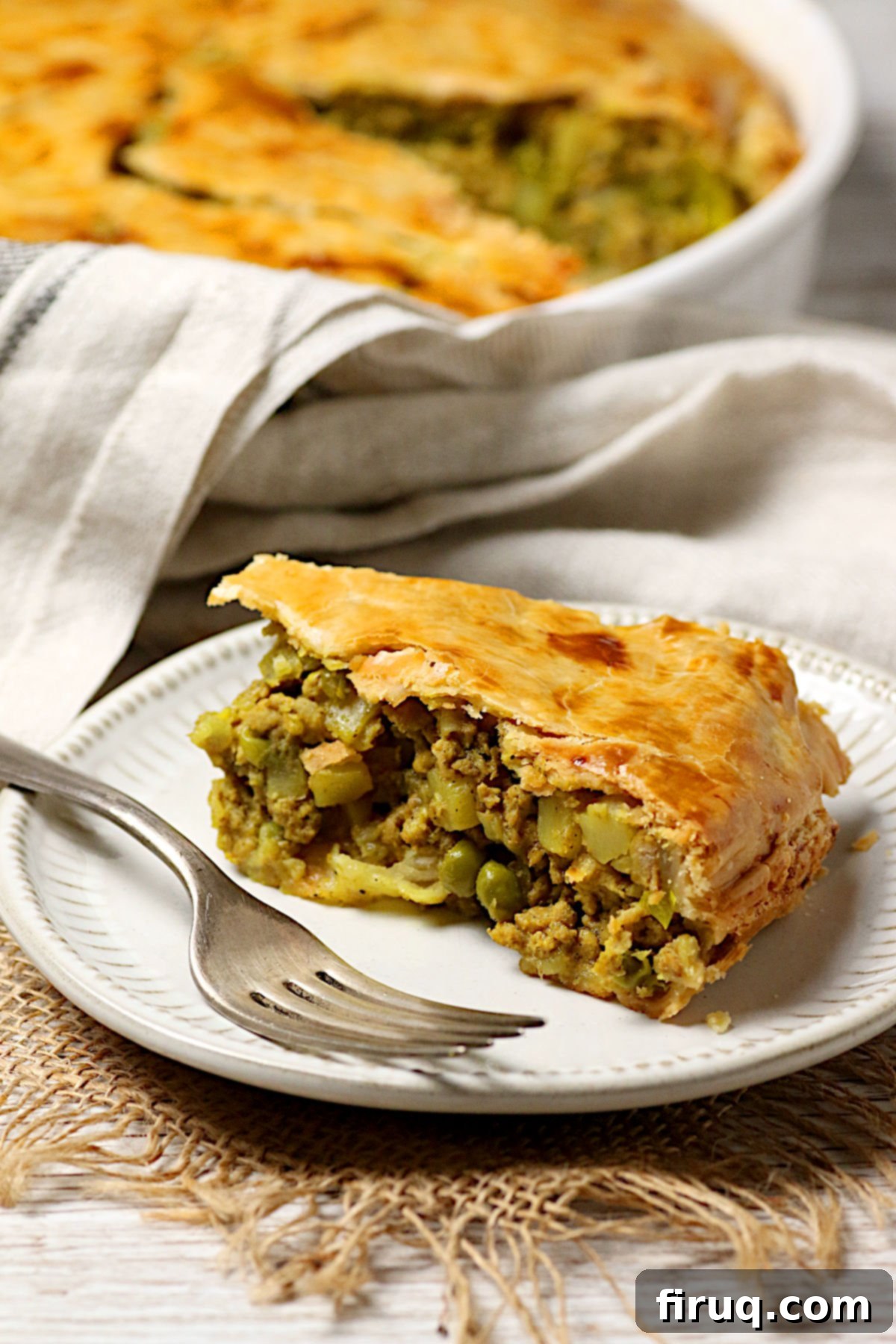 Serving of Chicken Samosa Pie A slice of Chicken Samosa Pie on a small white plate.