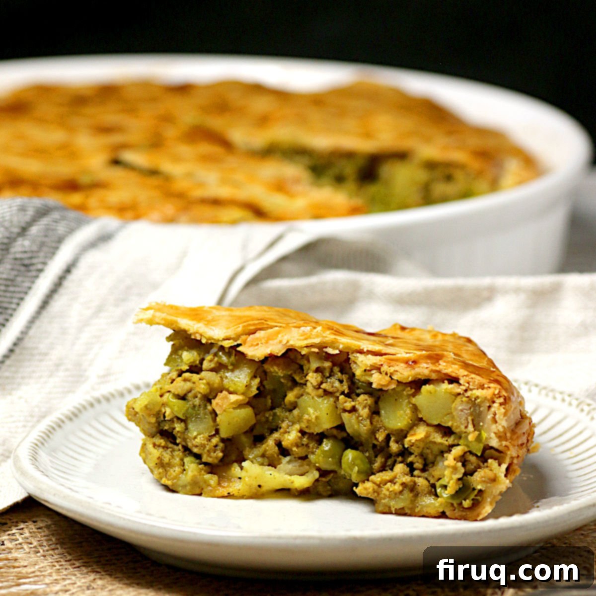 Homemade Chicken Samosa Pie A slice of Chicken Samosa Pie on a small white plate.