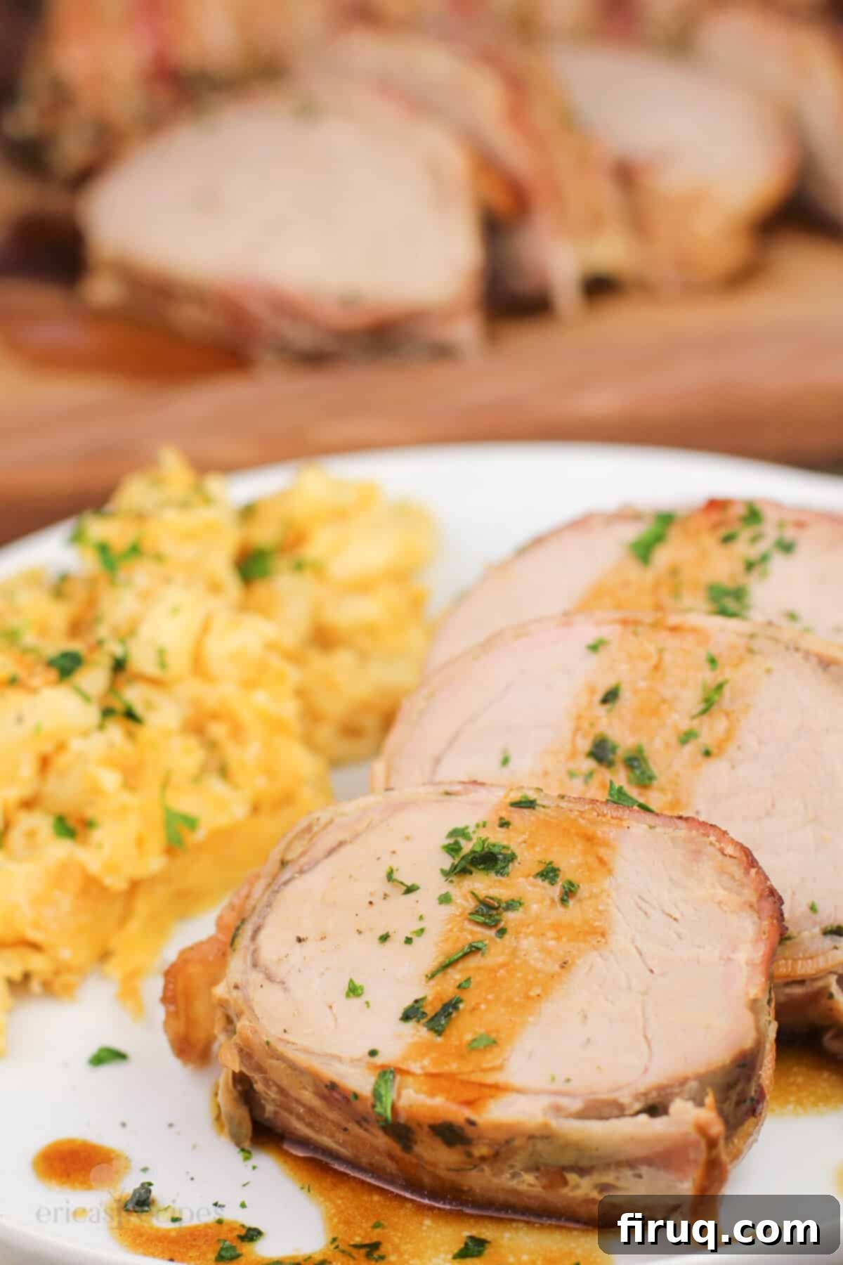 Easy Weeknight Roasted Pork Tenderloin 9 portion of prepared ork on white plate with mac and cheese