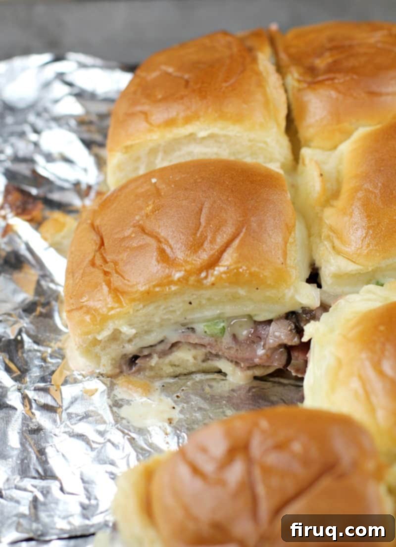 Grilled Philly Cheesesteak Bites 11 A single, perfectly grilled Philly cheesesteak slider, gooey with melted cheese and ready to be enjoyed.