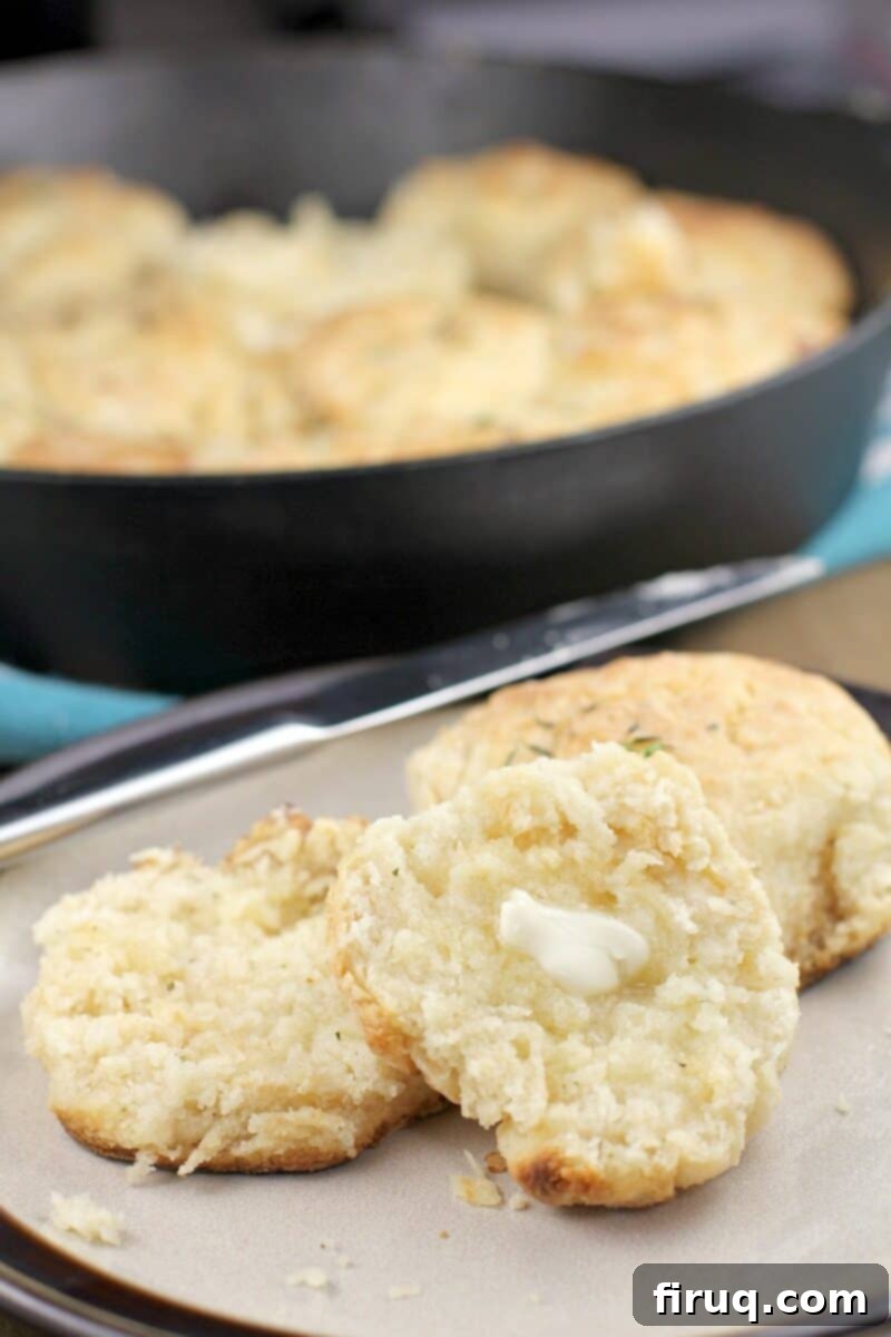 Aromatic Grilled Honey Thyme Biscuits 11 A warm grilled honey biscuit, split open with melting butter, on a plate.