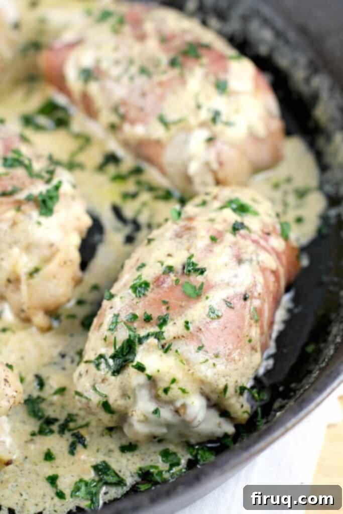 Instant Pot Chicken Carnitas 8 chicken thighs in a cast iron skillet, wrapped in prosciutto, cheese sauce spooned over