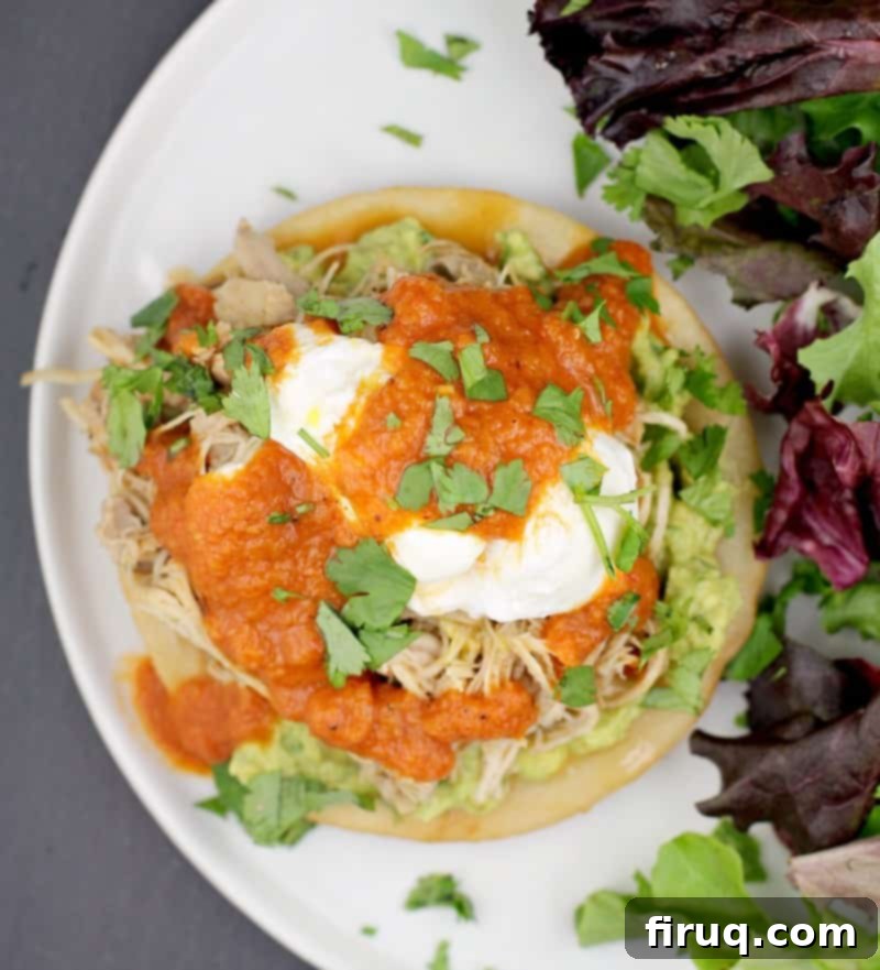 Huevos Rancheros Benedict 6 Top down view of the finished Mexican Eggs Benedict recipe on a white plate with a side salad