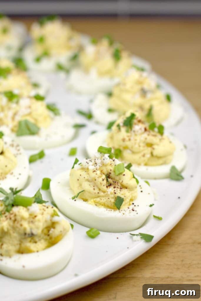Sunrise Ranchero Kick 9 deviled eggs on a white serving platter with green herbs sprinkled over
