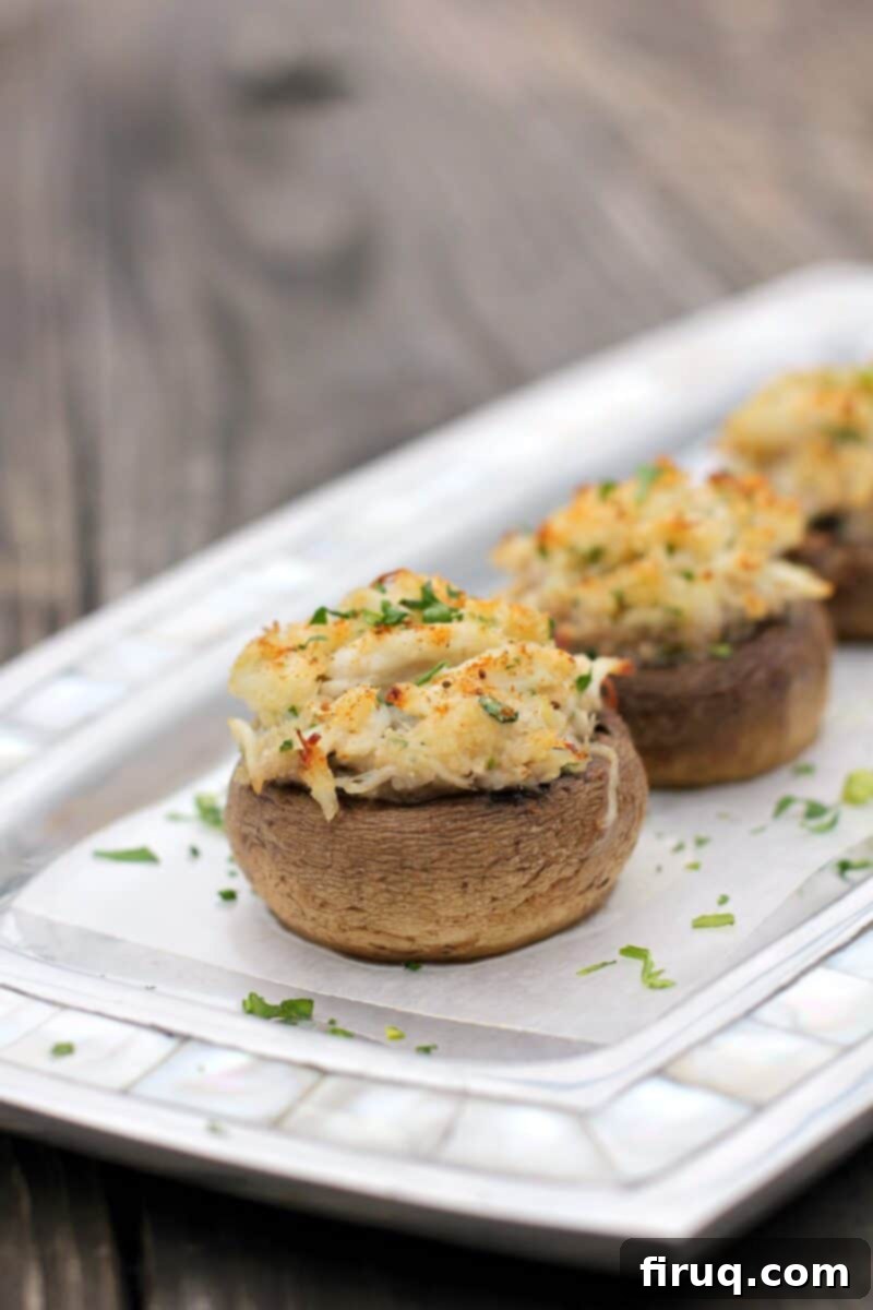 Crab-Filled Mushroom Caps 3 stuffed mushroom, centered, on serving plate topped with sprinkling of parsley