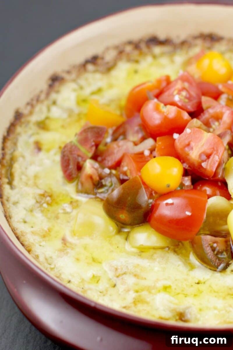 Warm Green Chili Artichoke Dip 2 baked green chili artichoke dip in a red ceramic dish topped with tomatoes and olive oil