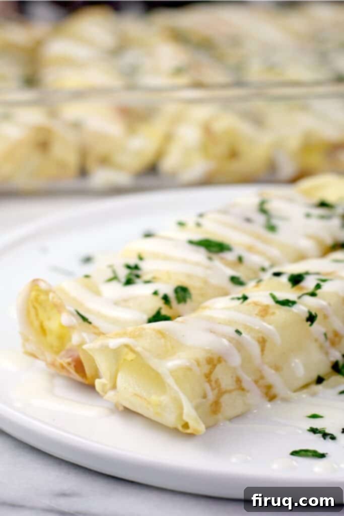Prosciutto and Cheese Crepes 7 two plated crepes on white dish; casserole dish in background