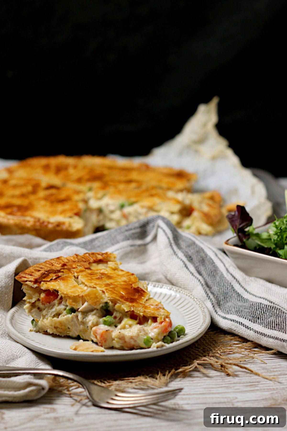 Slice of Chicken Pot Pie A perfectly sliced piece of homemade Chicken Pot Pie on a small white plate, showing the rich filling.