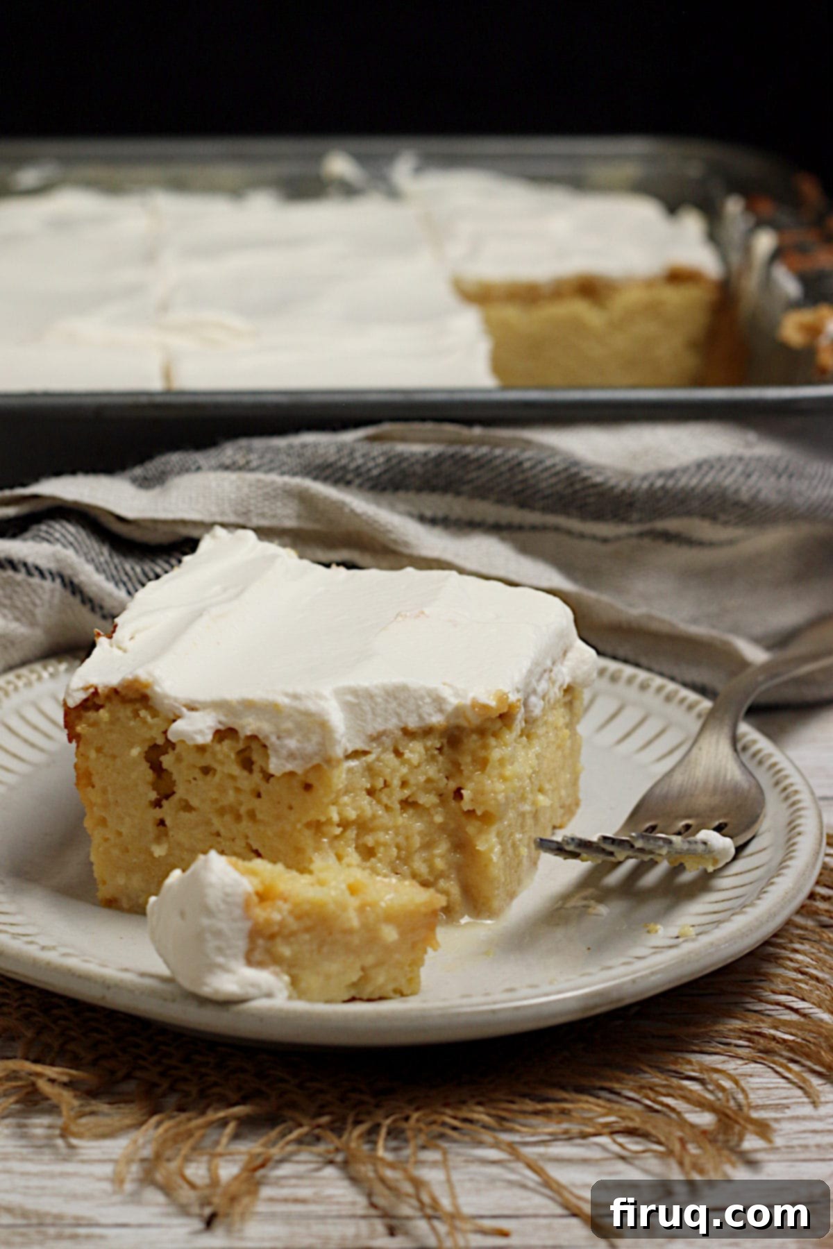 Served Gluten-Free Corn Tres Leches Cake Slice A slice of gluten-free Corn Tres Leches Cake on a small white plate.