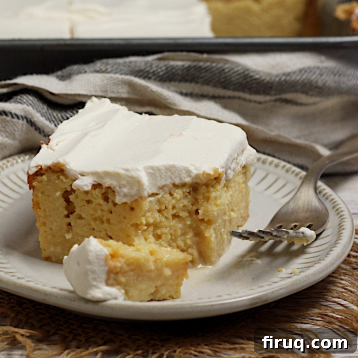 Gluten-Free Corn Tres Leches Cake Hero Shot A slice of gluten-free Corn Tres Leches Cake on a small white plate.