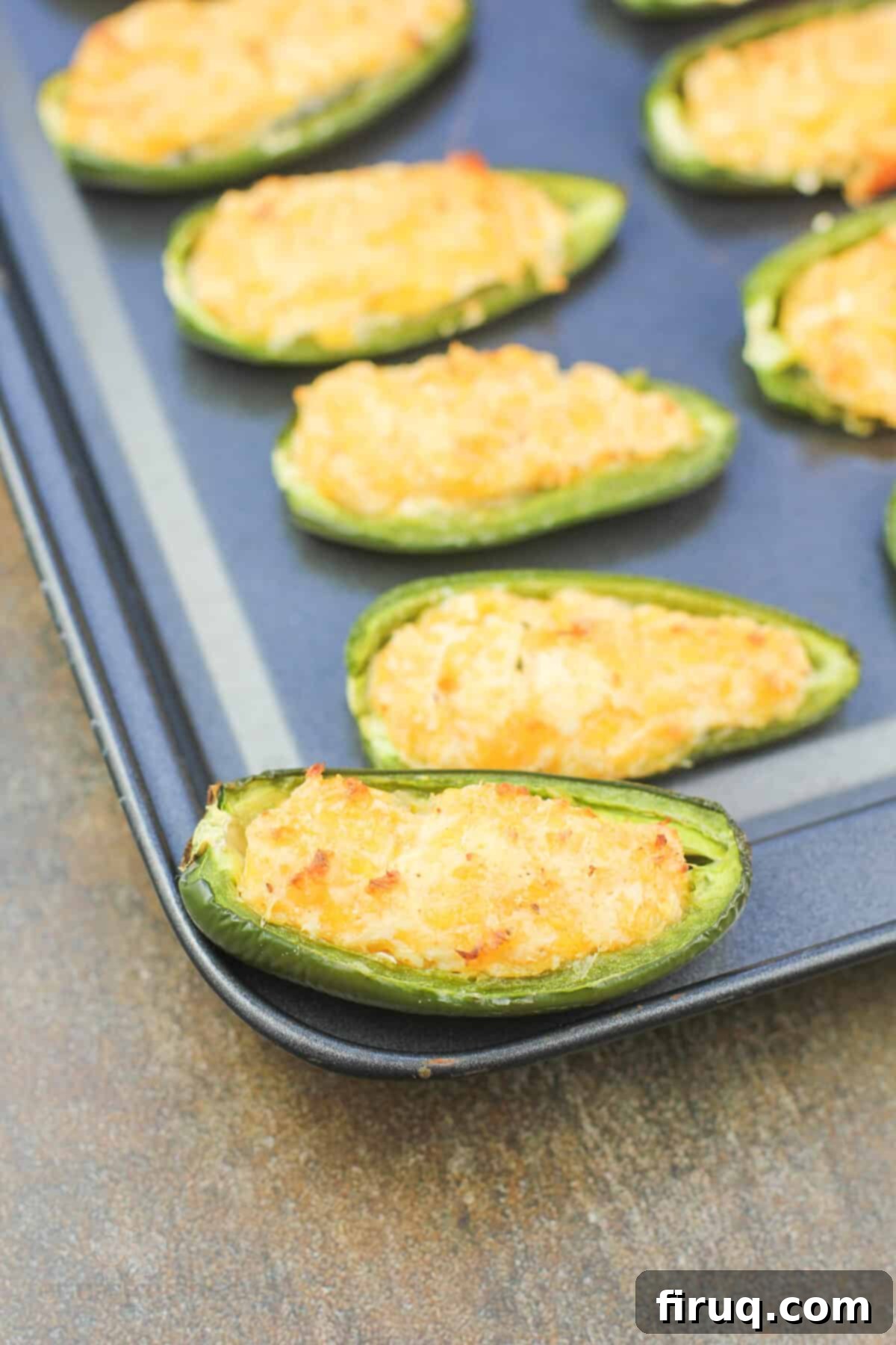 Spicy Shrimp Jalapeño Poppers 2 close view of a shrimp stuffed jalapeno on bake sheet