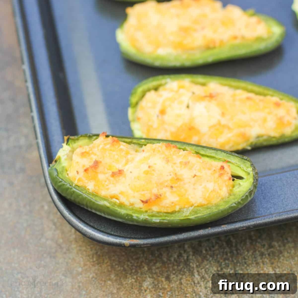 Spicy Shrimp Jalapeño Poppers 8 close view of a shrimp stuffed jalapeno on bake sheet