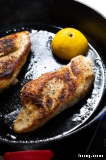 Flawless Cast Iron Chicken Breast 6 Golden-brown chicken breast expertly flipped in a cast iron skillet with a caramelized lemon half