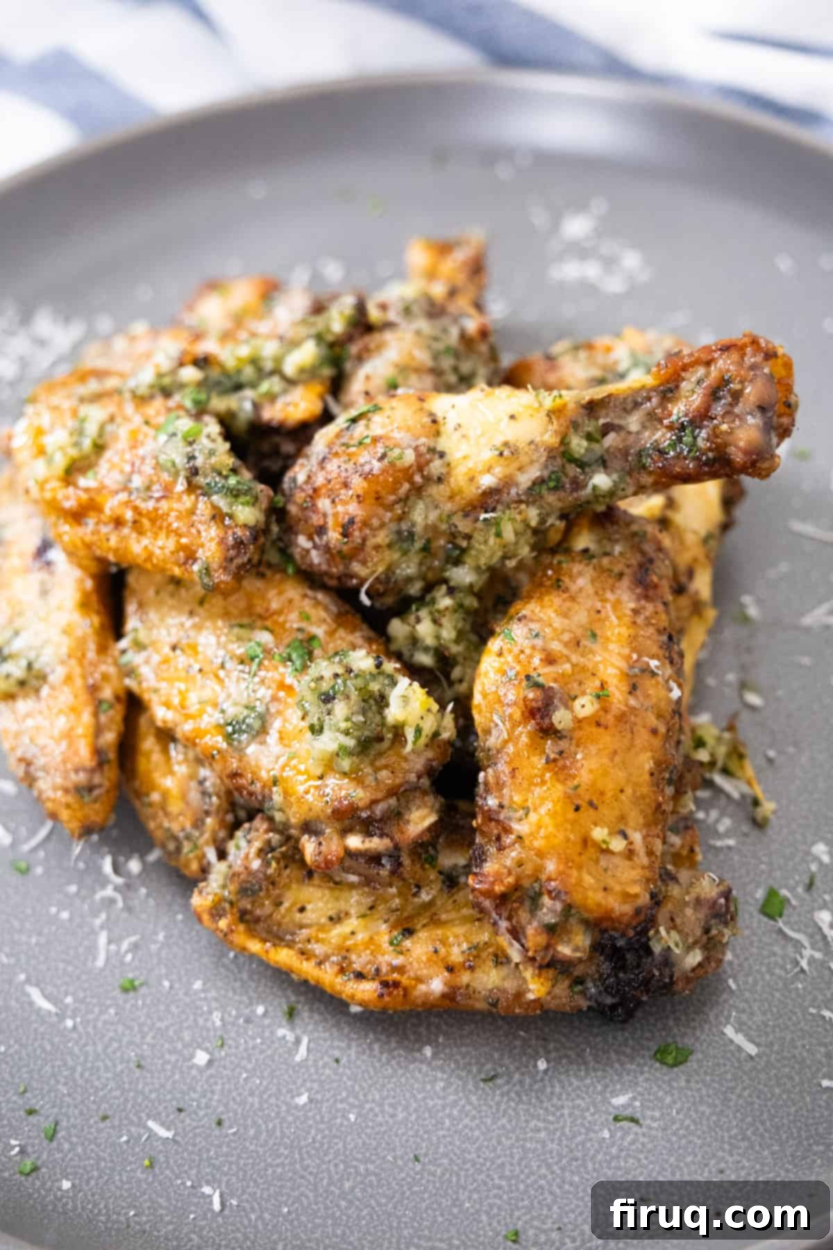 Crispy Air Fryer Garlic Parmesan Wings 2 Crispy air fryer garlic parmesan wings garnished with fresh parsley on a white platter, ready to be served