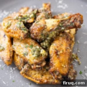 Crispy Air Fryer Garlic Parmesan Wings 9 Air fryer garlic parmesan wings piled neatly on a white plate, ready to eat and garnished with parsley